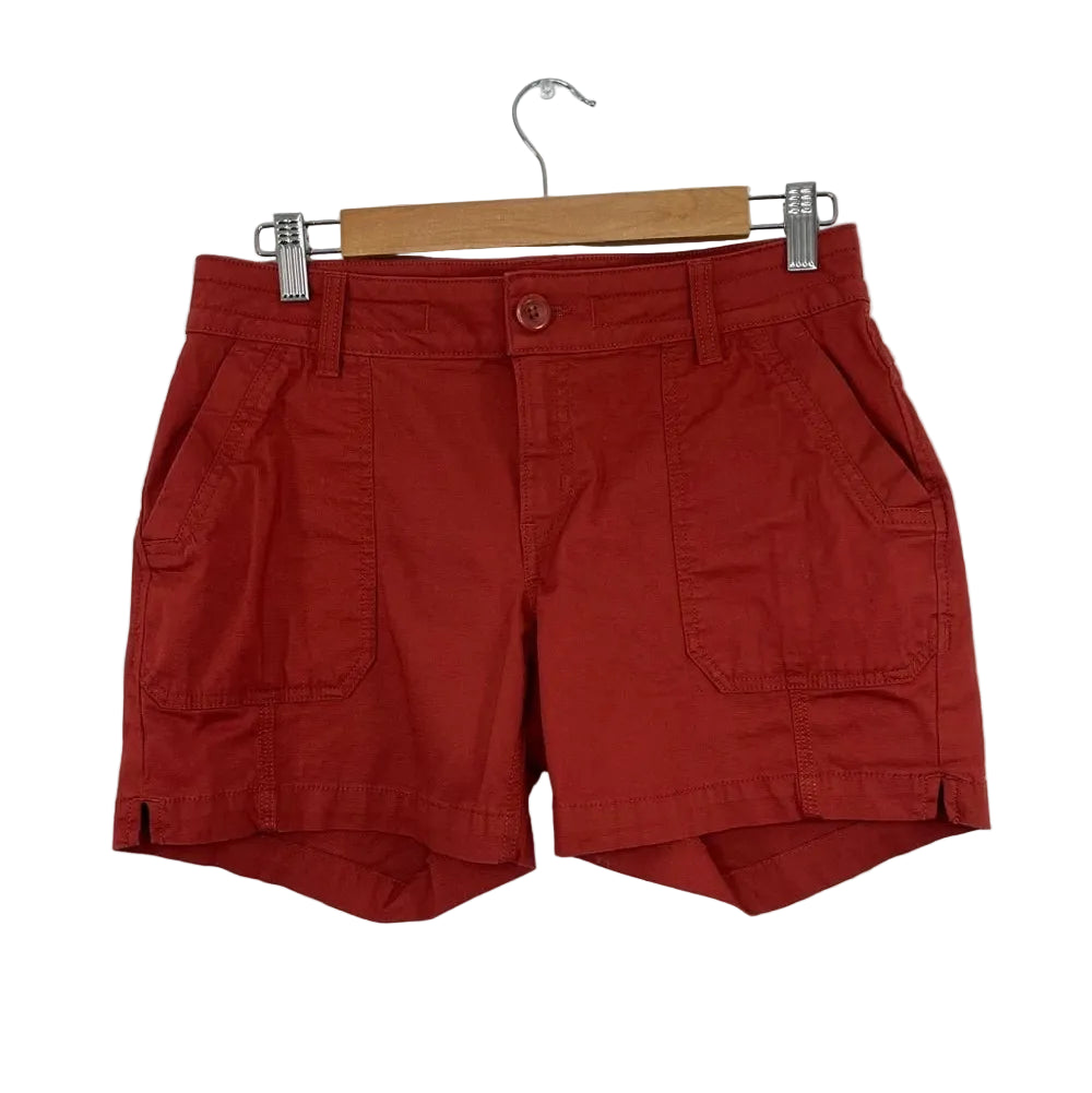 PRANA Women's ELLE 5" inseam shorts in terracotta red with front button and cargo pockets.