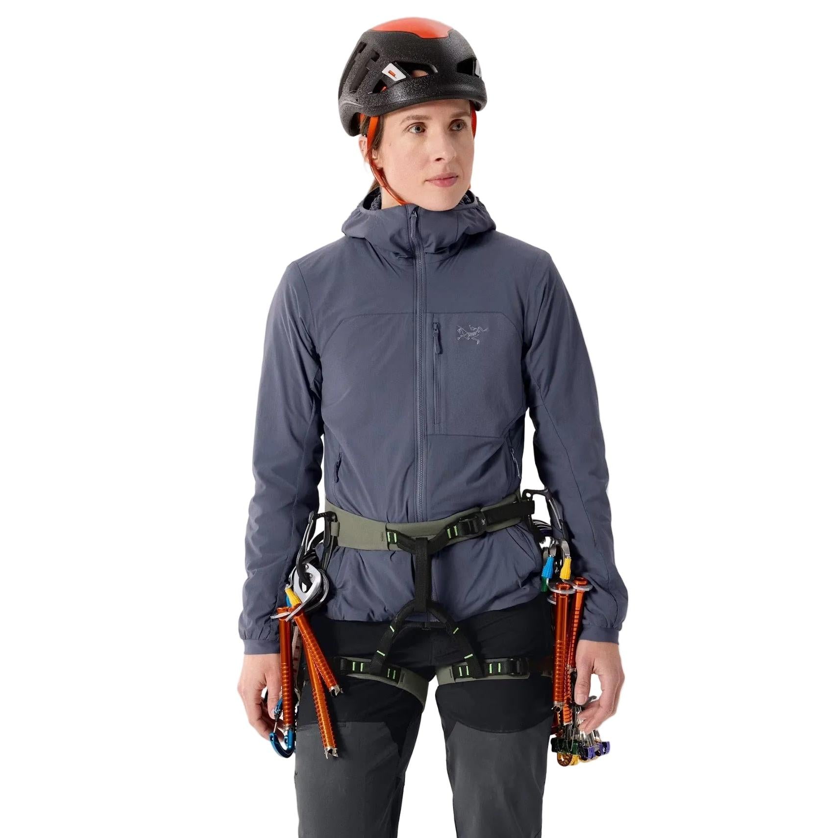 Person wearing Arcteryx AR - 385a climbing harness  including a helmet, jacket, and harness on a plain background