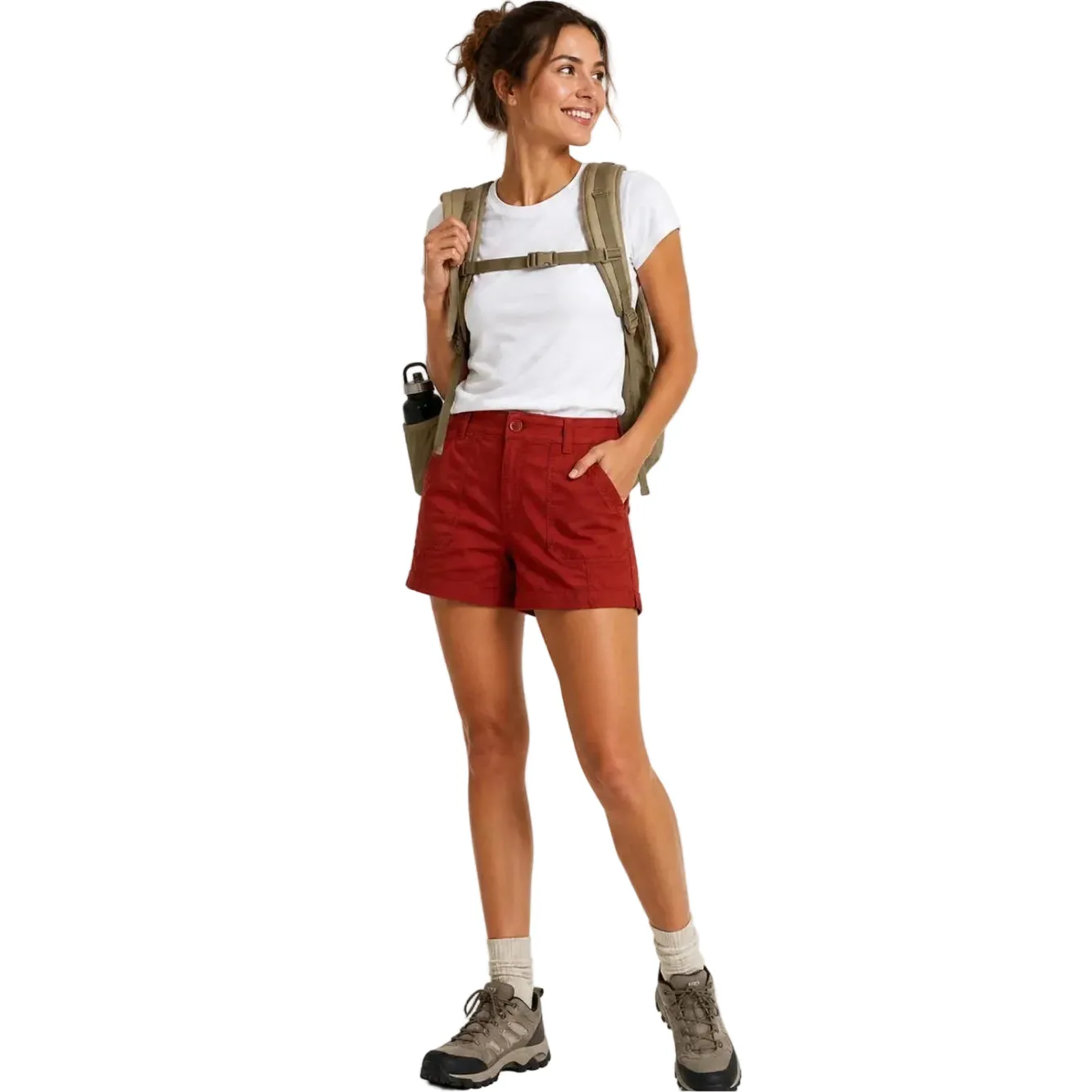 Woman in red PRANA ELLE 5" inseam shorts, white tee, hiking boots, and olive backpack.